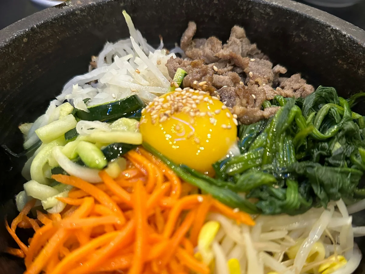 Bibimbap with vegetables, beef, egg and side dishes
