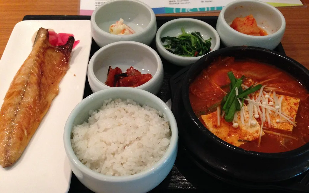 Korean meal with kimchi jjigae, grilled mackerel, rice and side dishes photographed at Incheon Airport