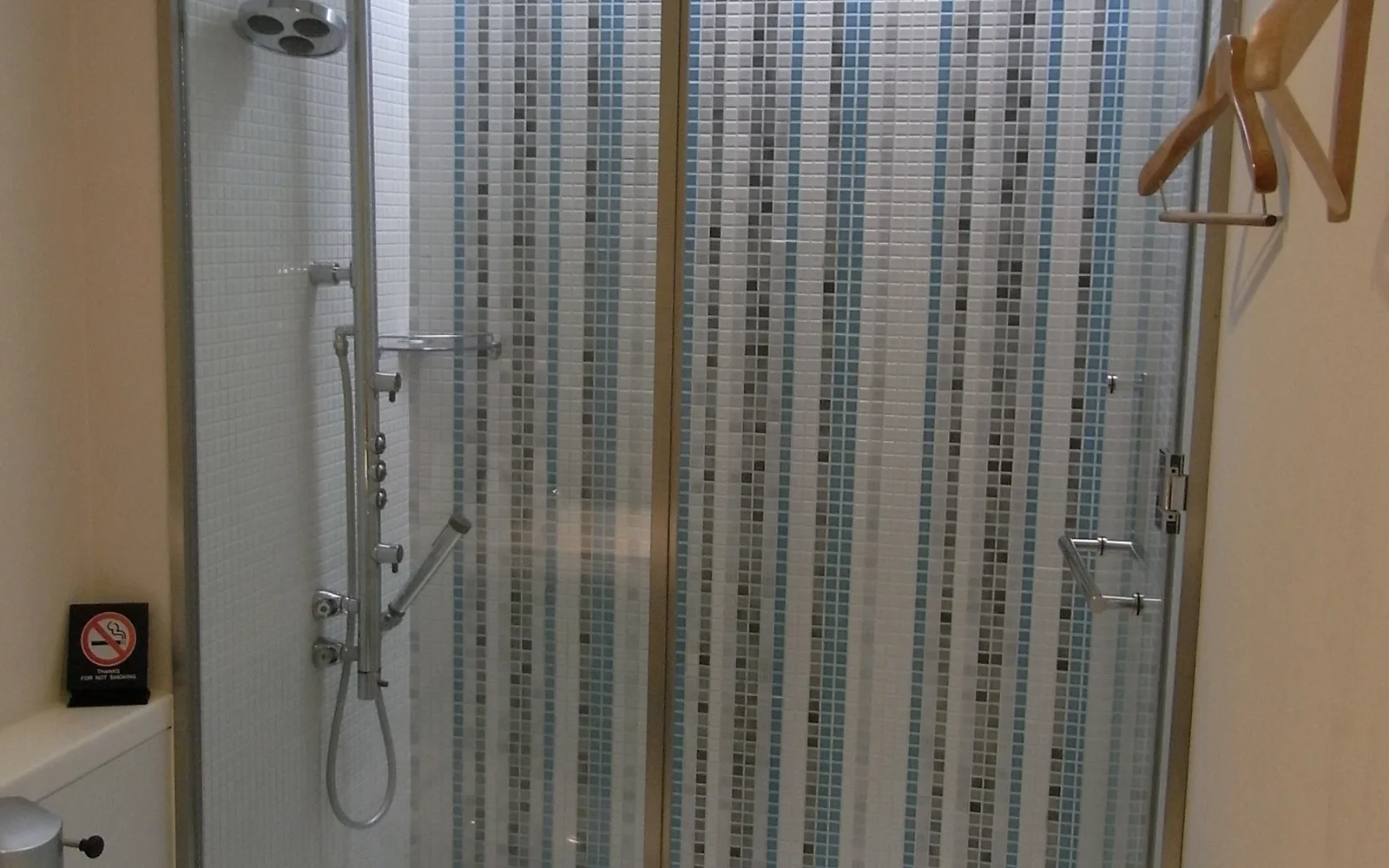 Illustrative airport lounge shower room with a glass enclosure