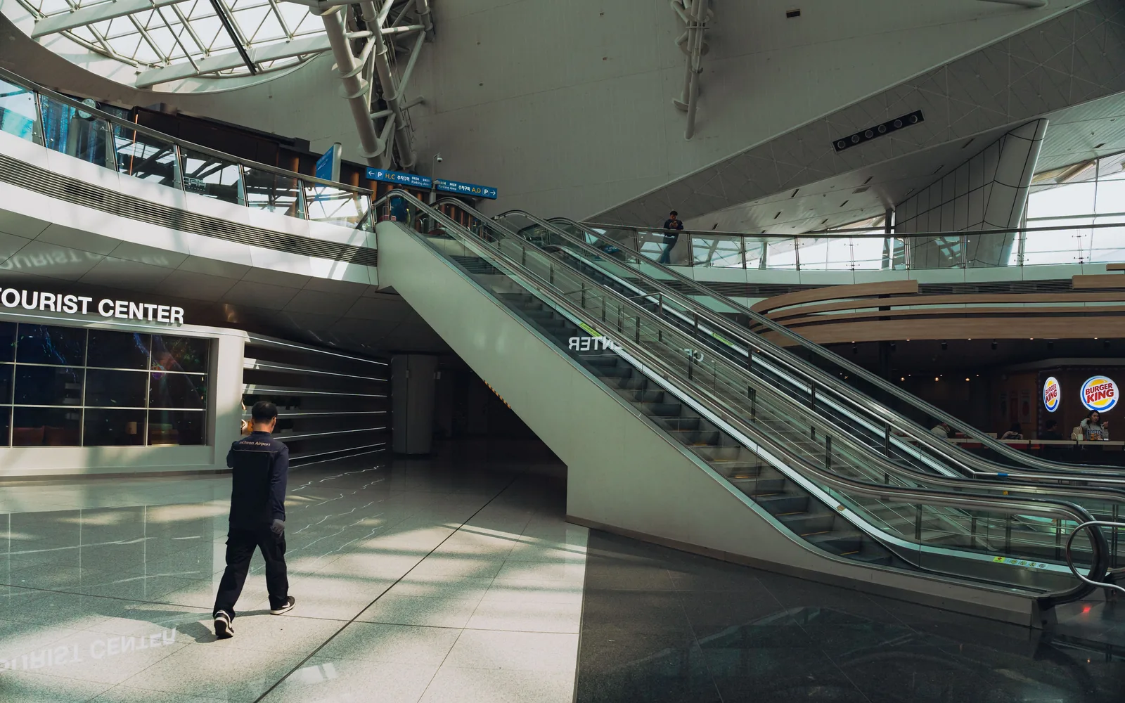 Incheon Airport interior with Tourist Center, escalators and parking signs