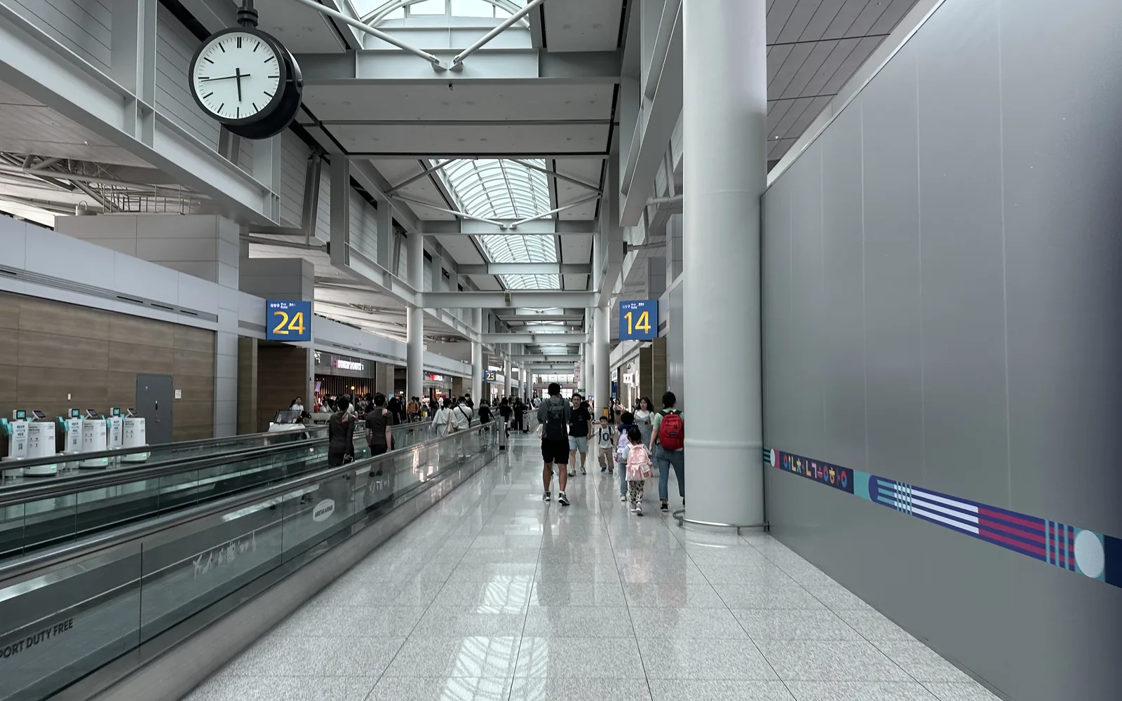Terminal 1 airside corridor with moving walkway and gate signs