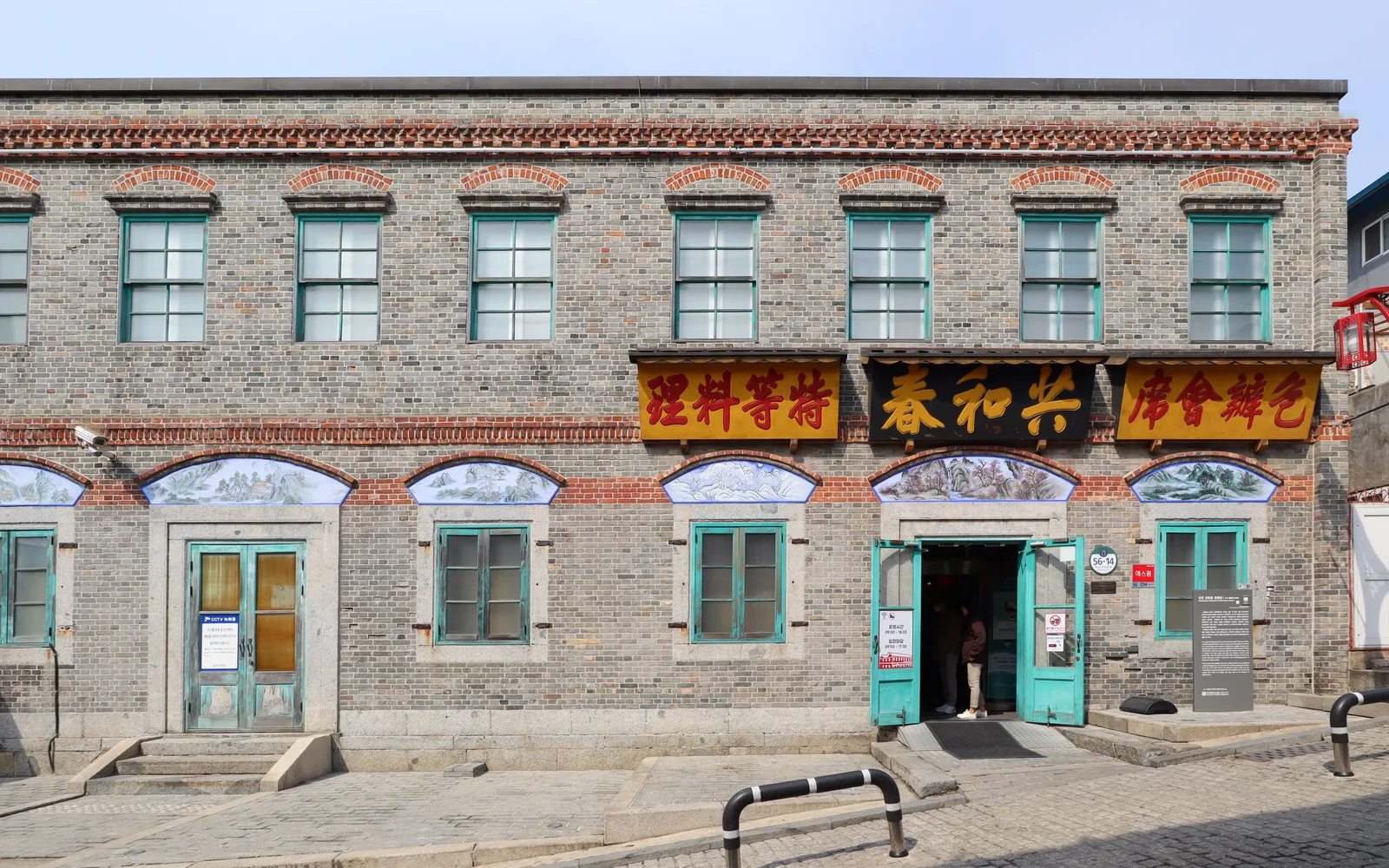 Gray-brick facade of the Jjajangmyeon Museum with teal doors
