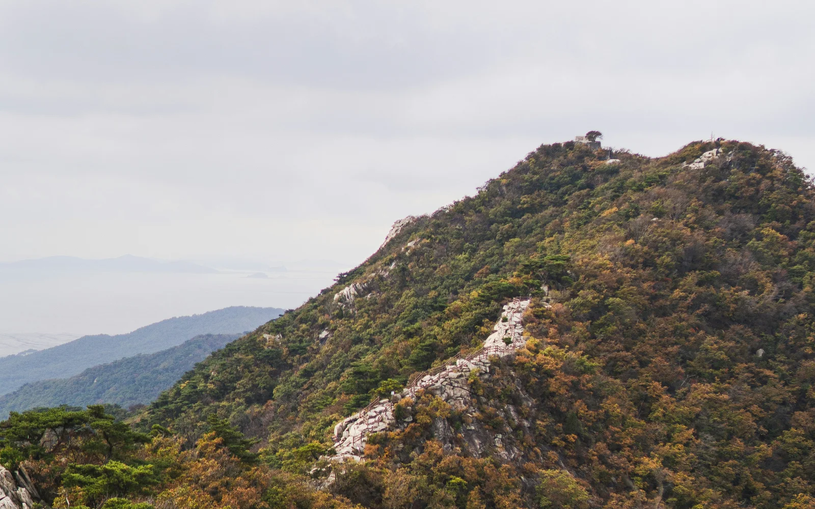Rocky ridge and forest on Manisan under an open sky