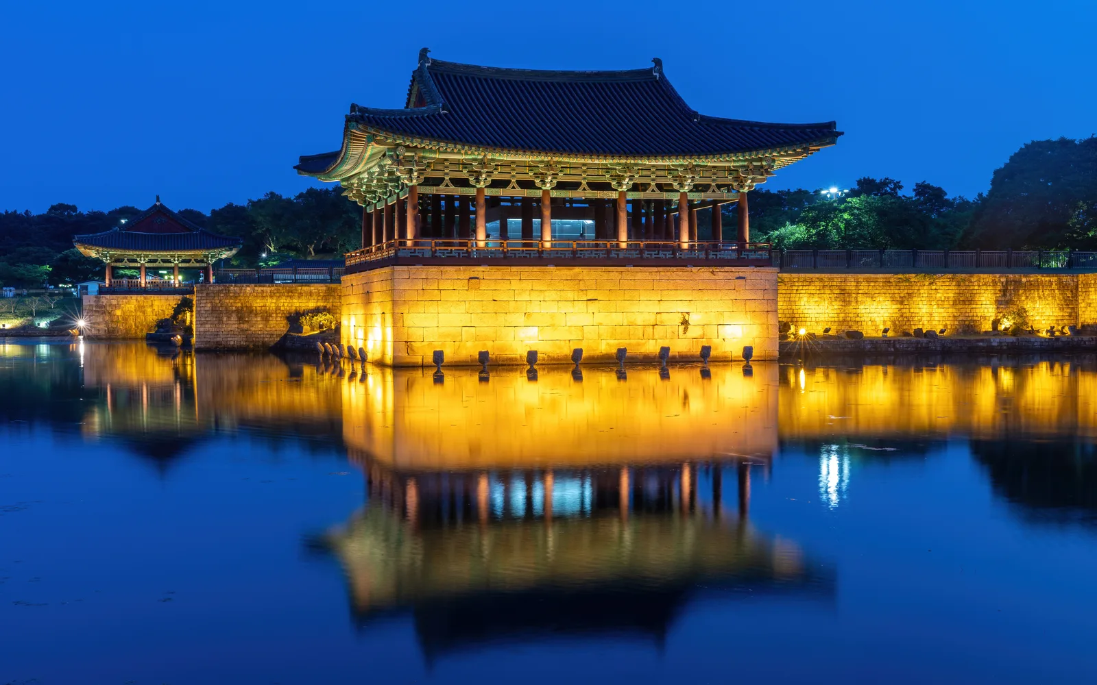 Illuminated Donggung Palace reflected in Wolji Pond at blue hour in Gyeongju