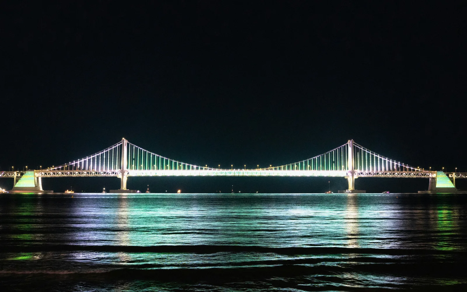 Illuminated Gwangan Bridge viewed across the water from Gwangalli Beach at night